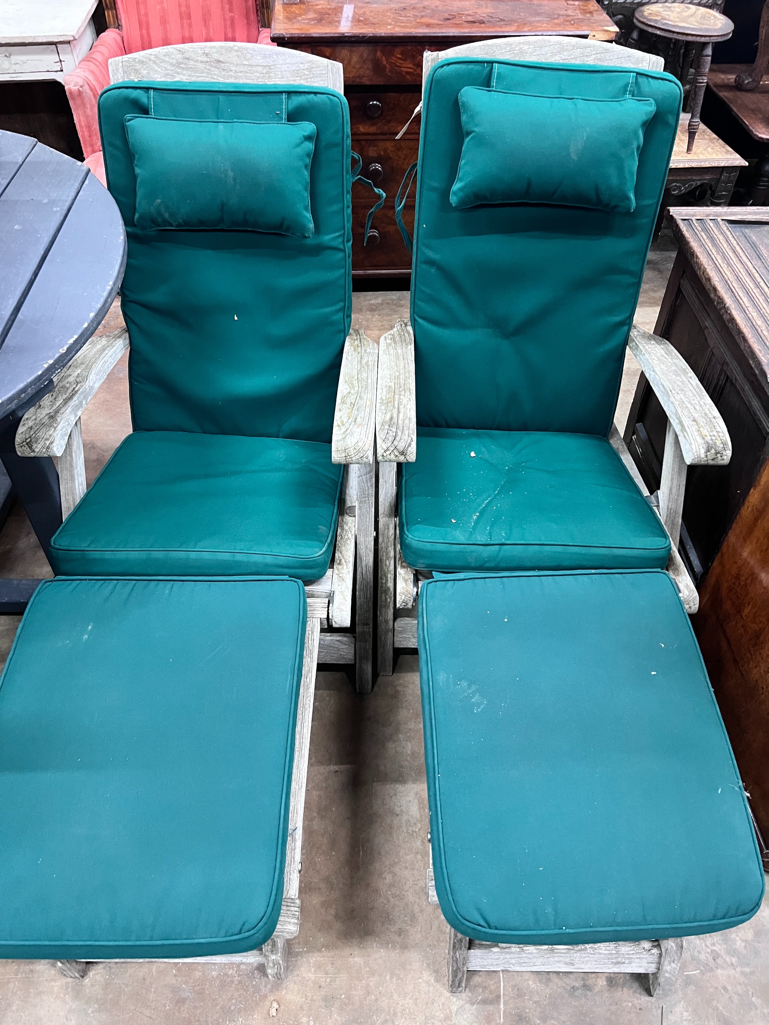 A pair of Indian Ocean weathered teak Burnham steamer chairs with green fabric squab cushions